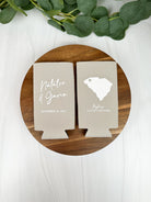 Custom wedding slim can coolers in the color of sandstone, featuring a state outline